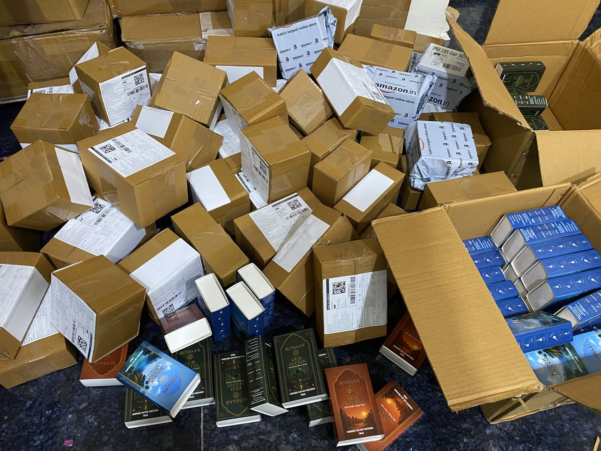 Cartons of SUNSAA hanging car perfume orders packed and labelled for dispatch, with Amazon.in shipping bags